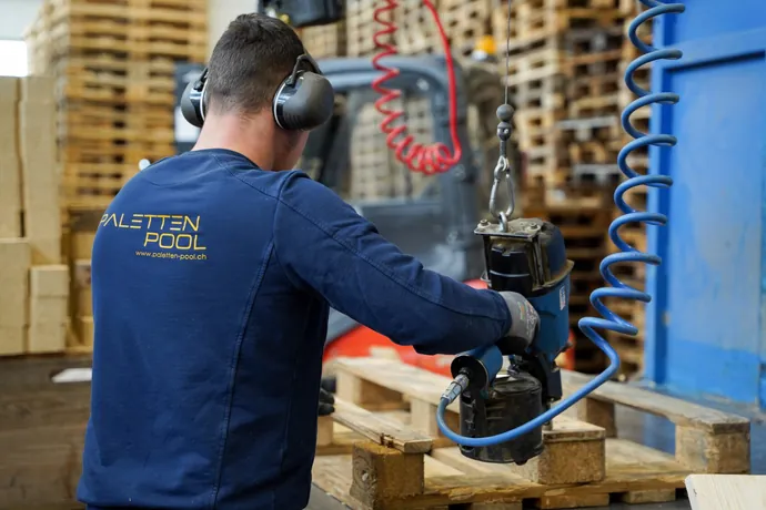 Un collaborateur de Paletten-Pool GmbH répare une europalette EPAL dans l'atelier